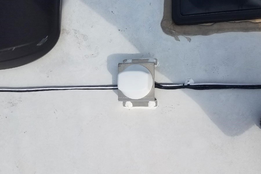 Top view of a correctly installed Mobile Mark external antenna on an RV. Mounting bracket is reinforced with caulk.